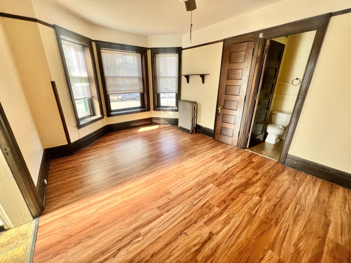 Kenosha apartments for rent - image - Step into this sunlit space with beautiful wood floors and easy access to a private bathroom, perfect for relaxation.