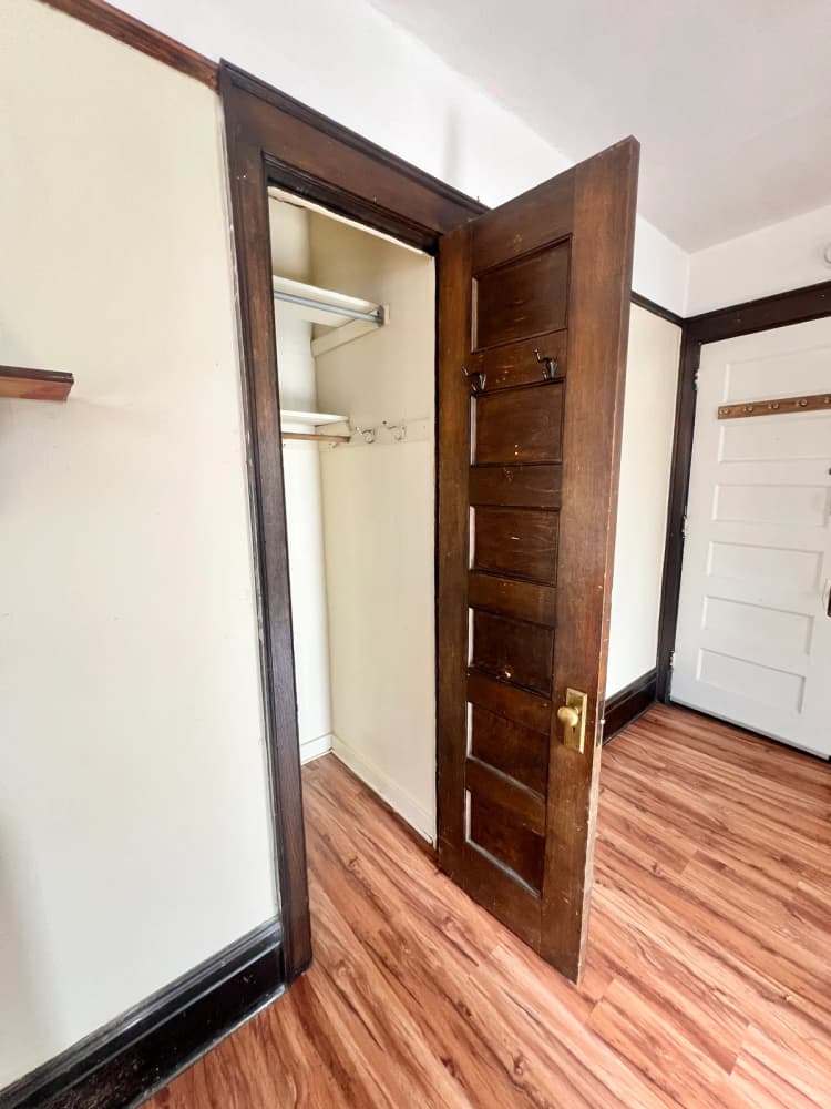 Kenosha apartments for rent - image - Explore this charming closet space with its classic wooden door and cozy atmosphere.