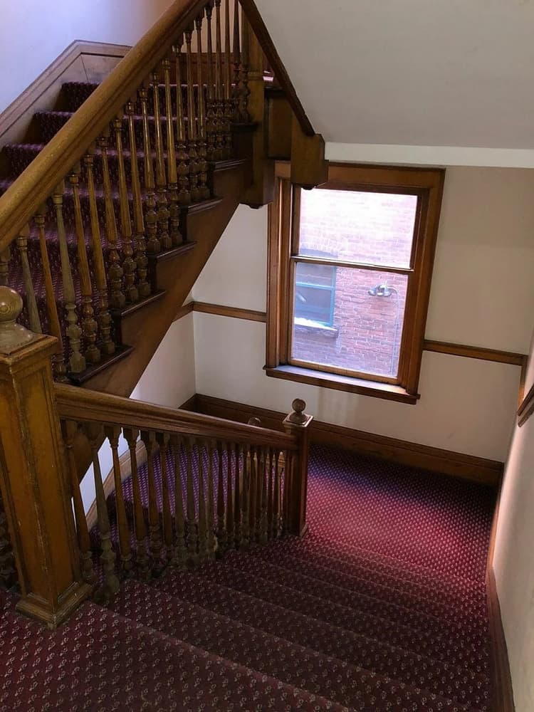 Kenosha apartments for rent - image - Step into elegance with this beautifully crafted wooden staircase, perfect for a warm and inviting home atmosphere.