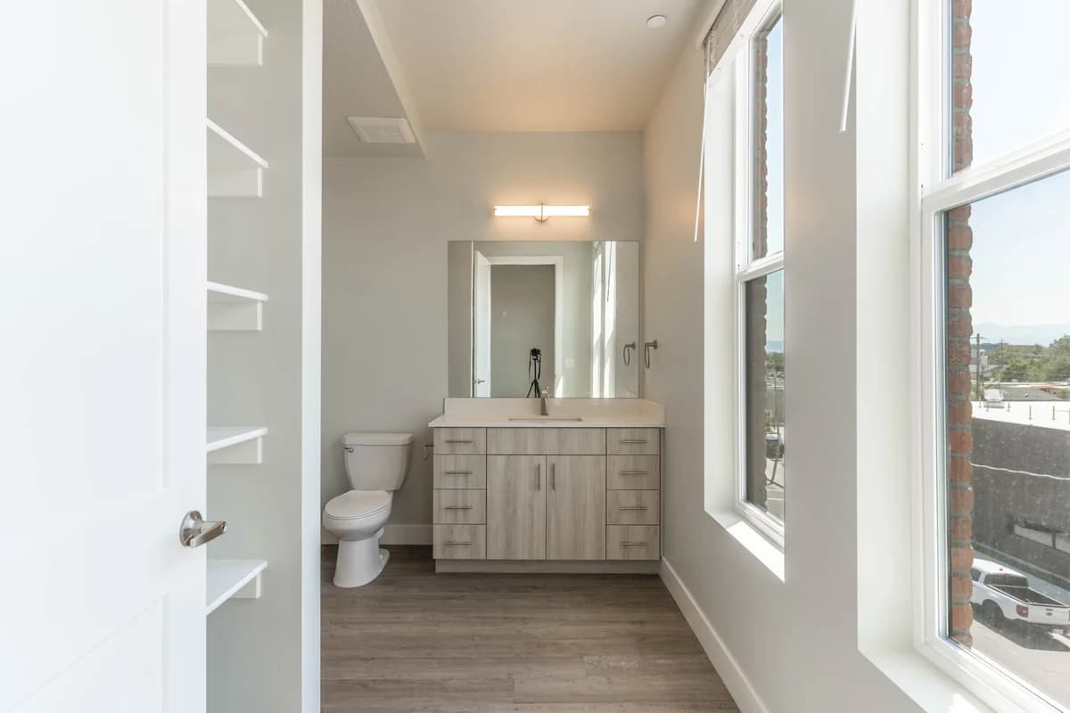 Kenosha apartments for rent - image - Bright and modern bathroom featuring a sleek vanity with ample storage, large mirror, and natural light from expansive windows.