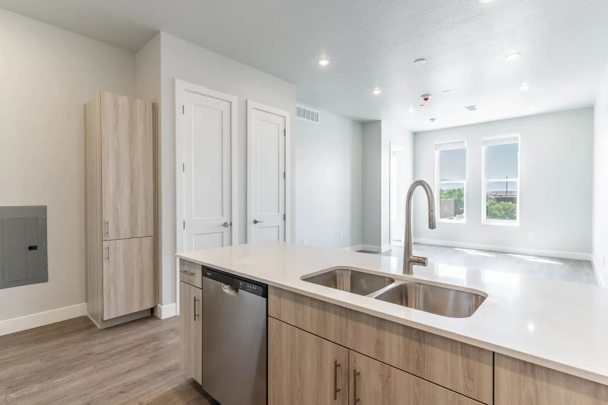 Kenosha apartments for rent - image - Modern open-concept kitchen with sleek countertops, stainless steel appliances, and bright natural lighting from large windows.